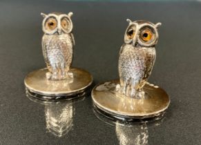 A pair of George V novelty silver owl menu holders, realistically modelled with glass eyes, on plain
