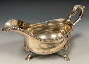 A George III silver sauce boat, monogrammed FMM, gadrooned rim, acanthus leaf capped scrolling