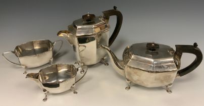 A George V silver four piece tea set, comprising Ebony handed Teapot and Hot water jug, twin handled