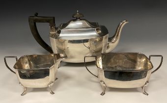 A George V silver three piece tea set, of canted rectangular form, the teapot with ebony handle