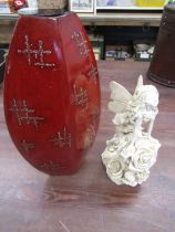 A ceramic fairy and a red Oriental vase