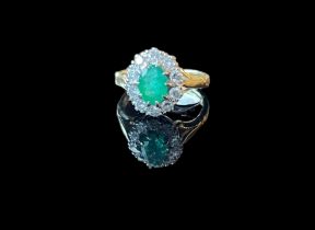 18ct gold diamond and Emerald cluster ring. An oval cut emerald within a surround of brilliant cut