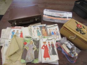 Sewing basket with contents, buttons, suitcase of vintage dress patterns and a new craft tape