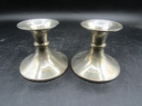 A pair of silver candlesticks- weighted