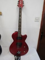 Daisy Rock electric guitar with red solid body and strap