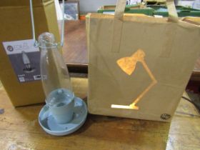 A brown paper bag lamp with image of angle poise lamp when lit and a Foras oil style light