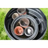 Plasic dustbin full of garden pots