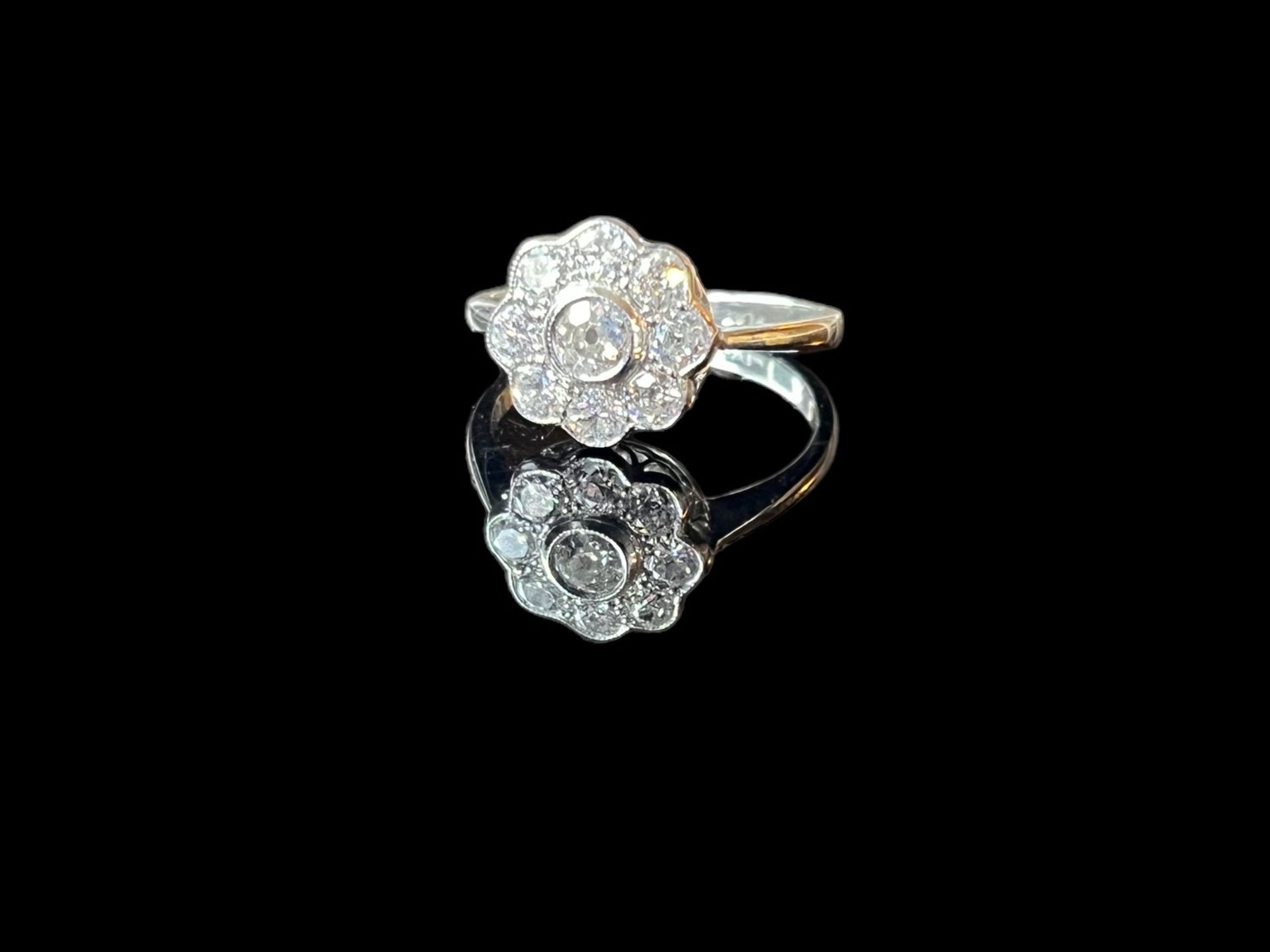 A Diamond daisy cluster ring set in platinum size O.