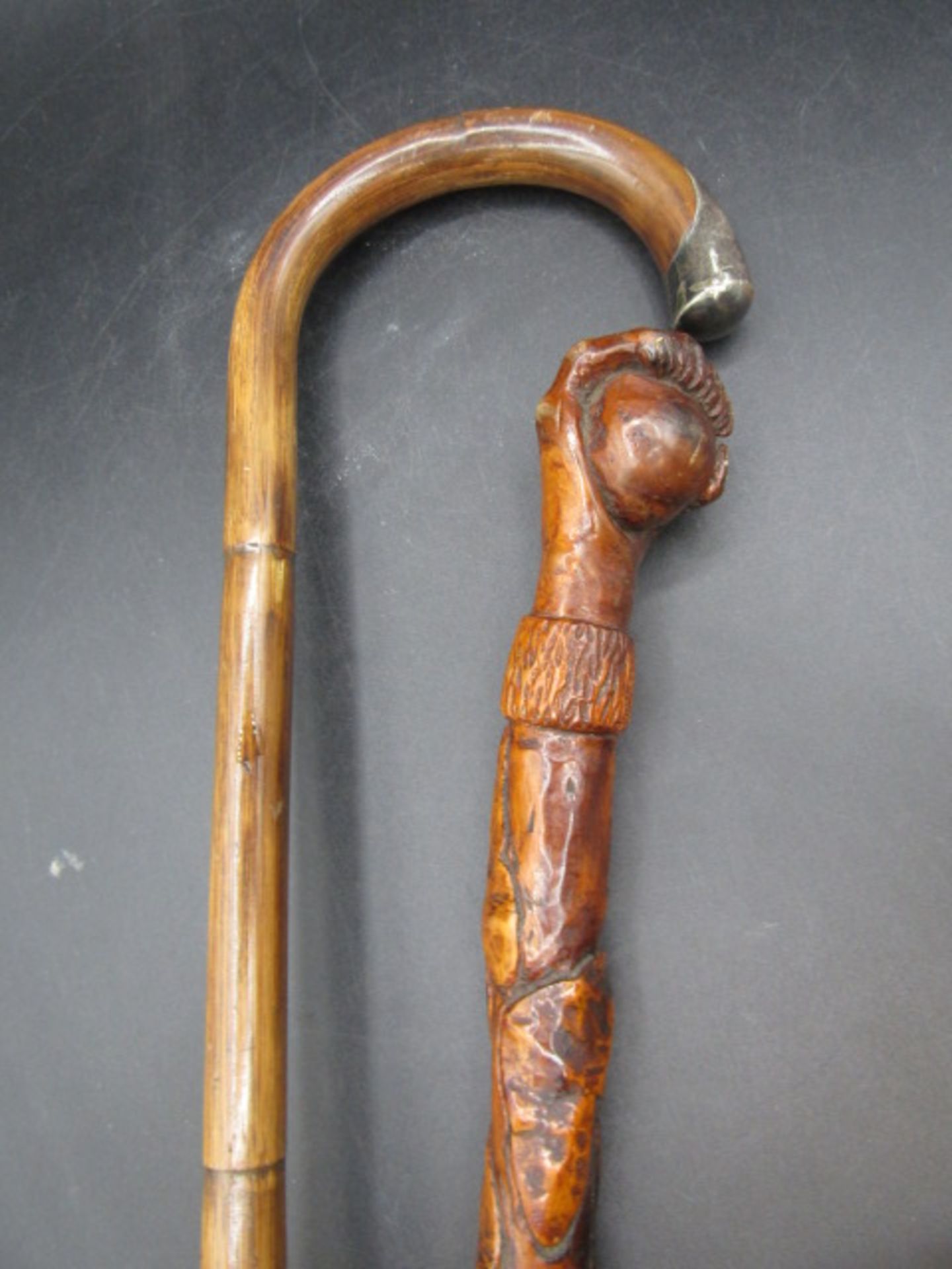 A carved walking cane with a hand clasping a ball with carved ivy down the cane plus a silver tipped