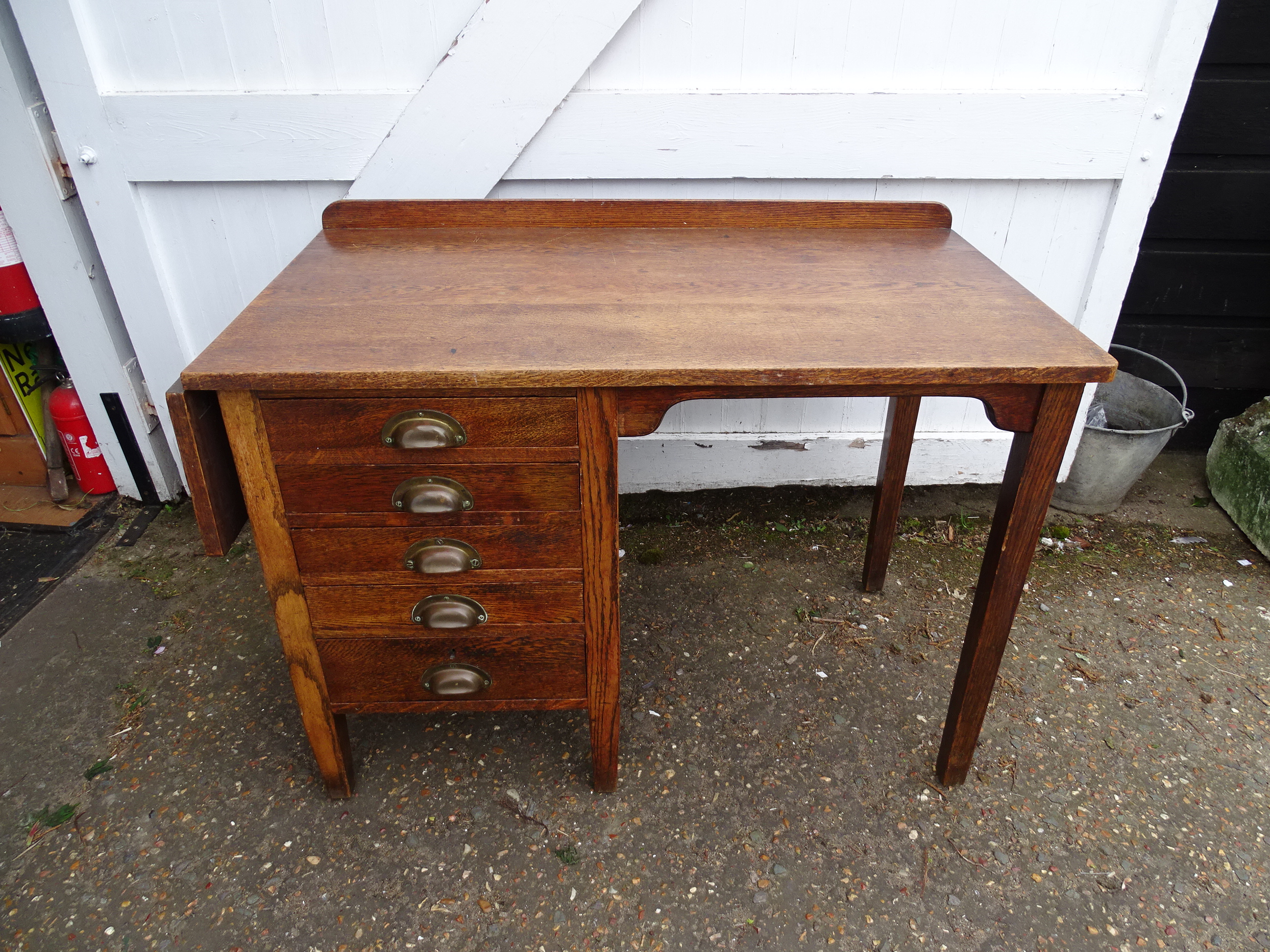 1930's George V extending single pedestal oak desk stamped G. R .V with 5 drawers and brass cup