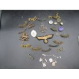 WW2 iron cross and various insignia badges and patches plus a charm bracelet