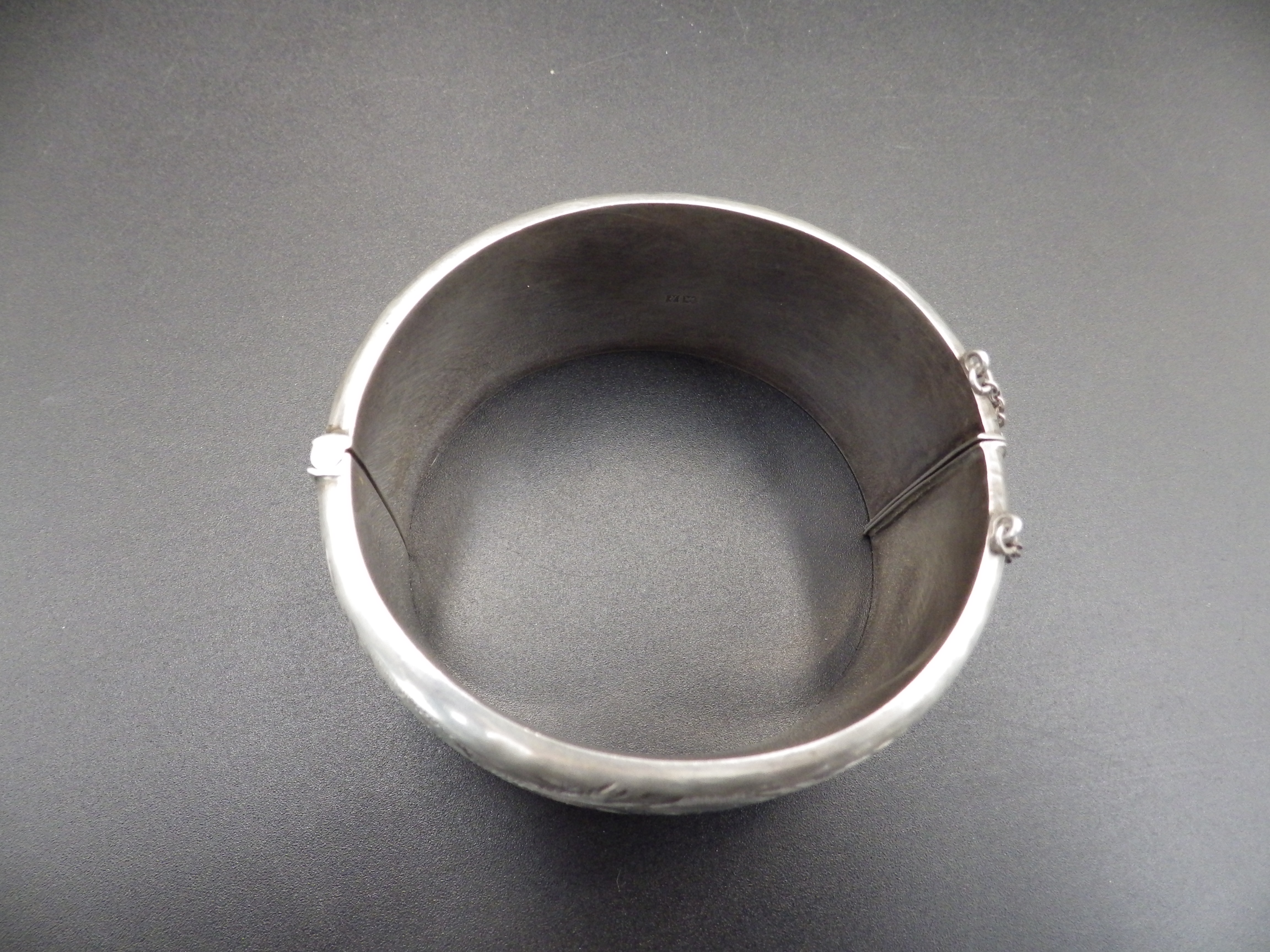 A silver hallmarked hinged bangle with safety chain (Birmingham 1966 by Ronex) 49.18g total weight. - Image 4 of 4