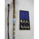 A souvenir badge walking stick, cased epns teaspoons and a vintage poker