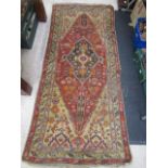 a vintage Eastern red ground rug 210x90cm