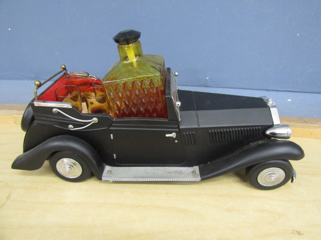 A musical tin plate Rolls Royce decanter with bottle and glasses
