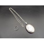 A silver hallmarked locket on a chain (Birmingham 1978) and a silver ring size M, total lot weight