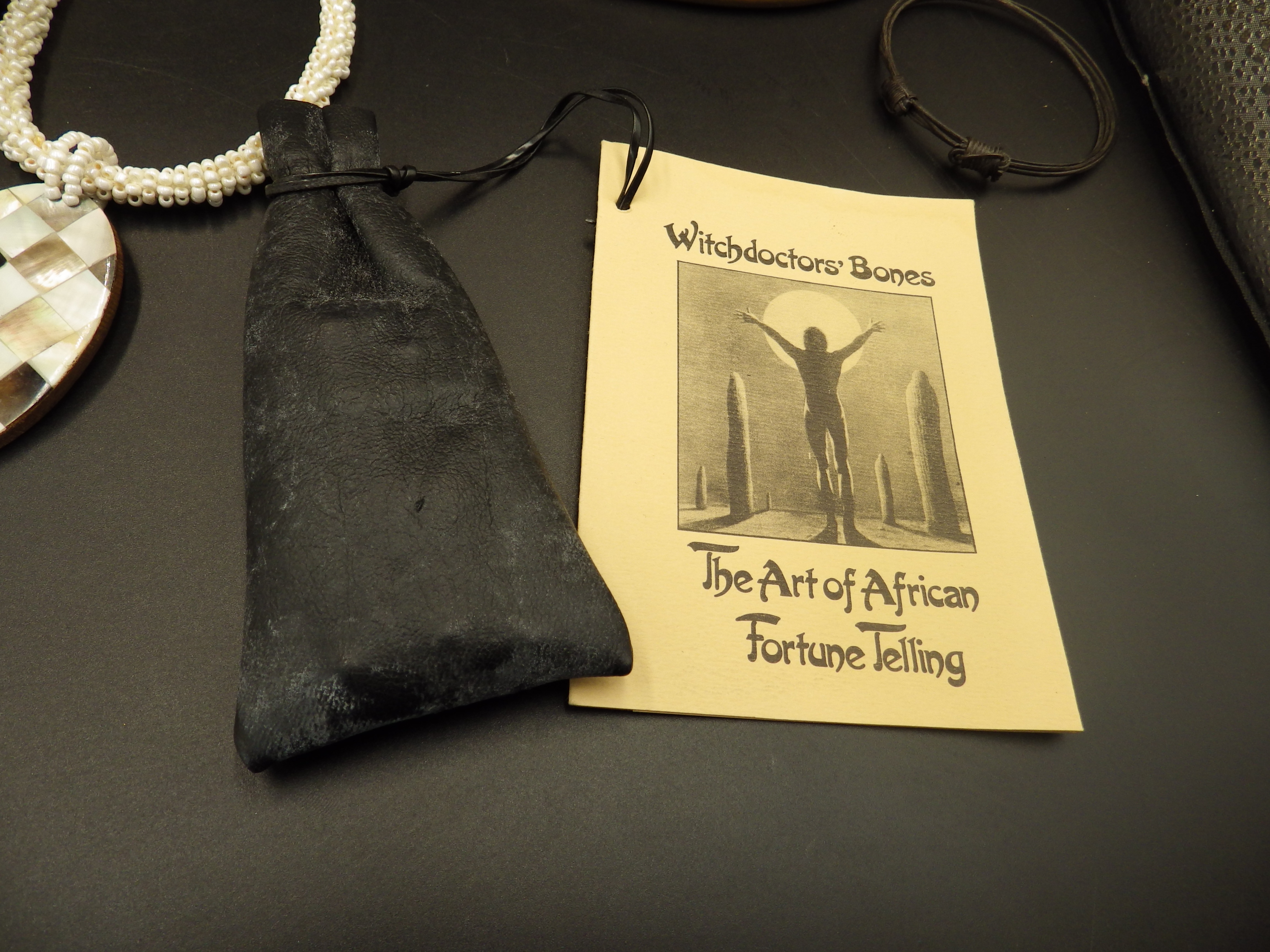 A box containg tribal themed jewellery and 'Witchdoctor' fortune telling bones in a pouch - Image 2 of 5