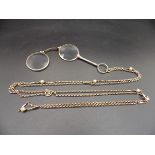 A double lorgnette marked 9 kt, on a gold chain marked 9 ct with decorative sphere detail, the chain