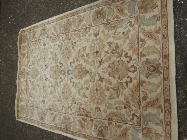 A cream ground wool rug 250x170cm