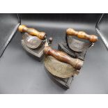 3 box irons with brass? heat shields and wooden handles together with slugs to incl 2x J & J Siddons