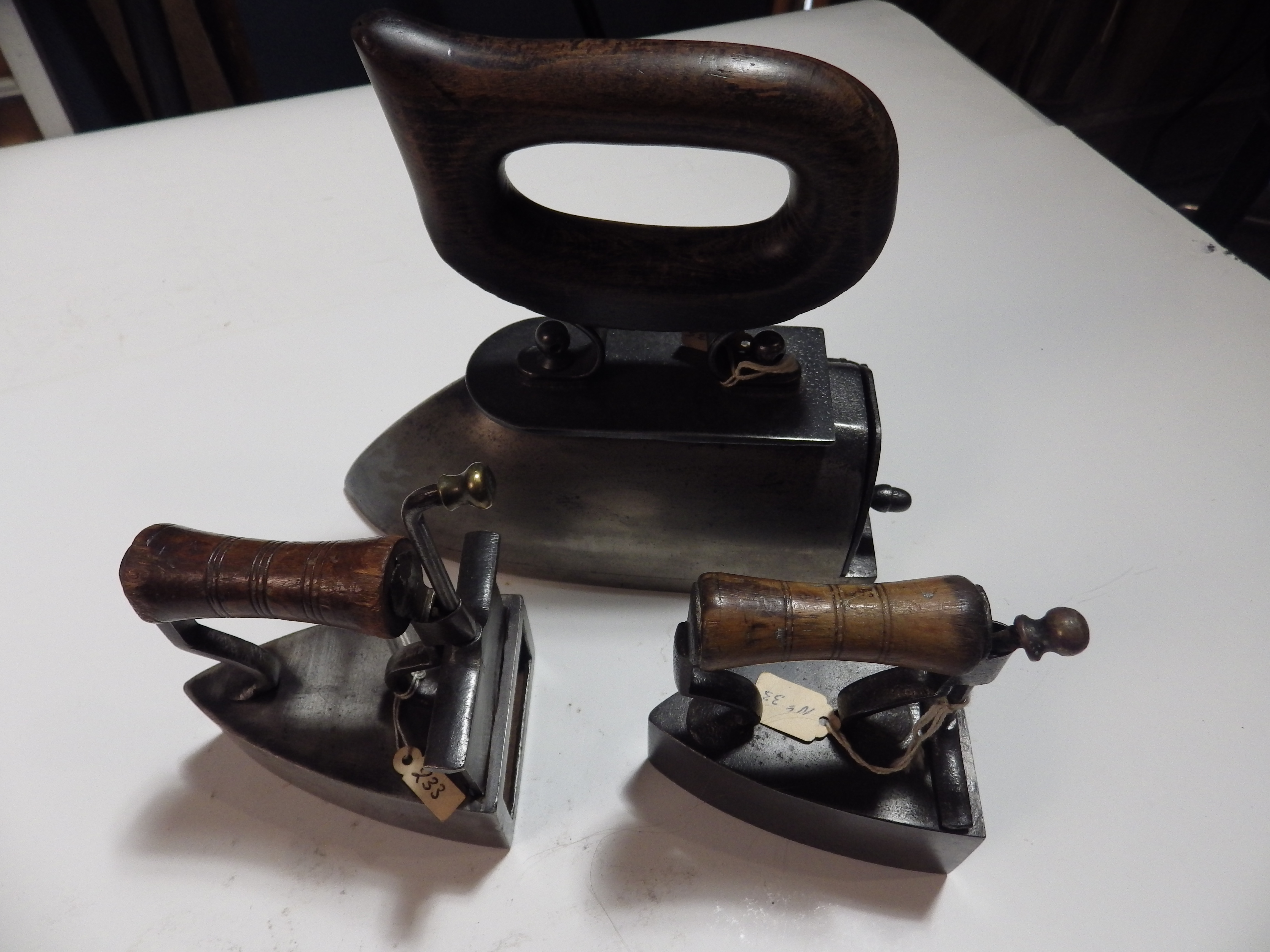 3 box irons with wooden handles - 2 small, one with slug and large GM no. 39454475 with slug