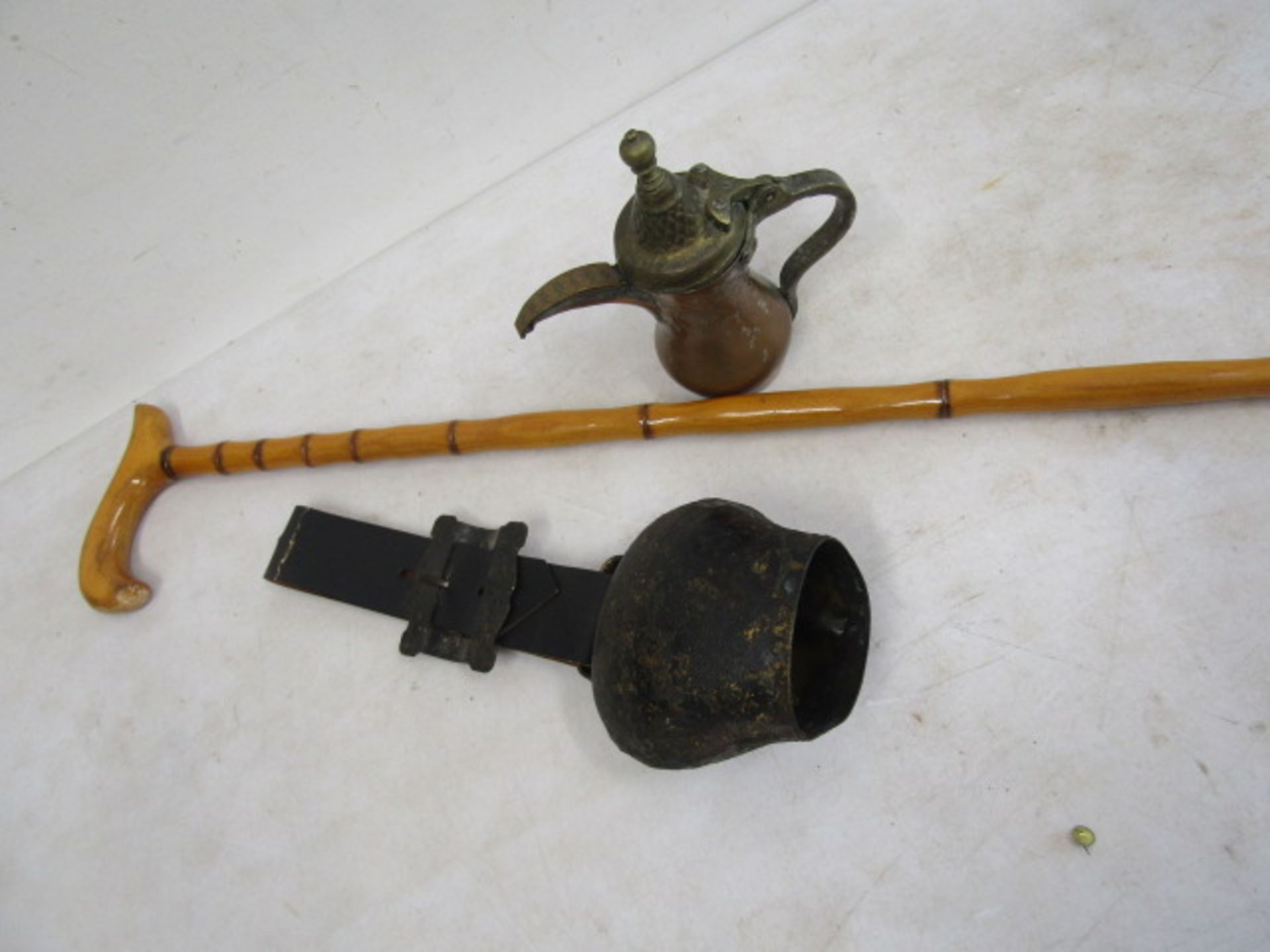 An Islamic teapot, walking cane and cow bell