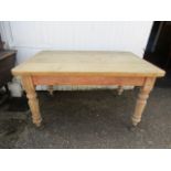 A vintage pine kitchen table with drawer and casters 135x35cm
