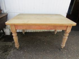 A vintage pine kitchen table with drawer and casters 135x35cm