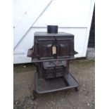 The Wee Ben tailors cast iron laundry stove with ornate door decorations incl two tailor goose irons