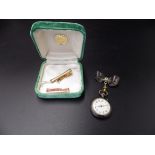 An early 20th C ladies lapel watch in a 'gun metal' case, with a bow pin fastening, and a 14ct
