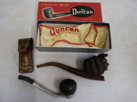 A Falcon pipe and a carved jester pipe in a Duncan box along with pipe cleaner in leather pouch