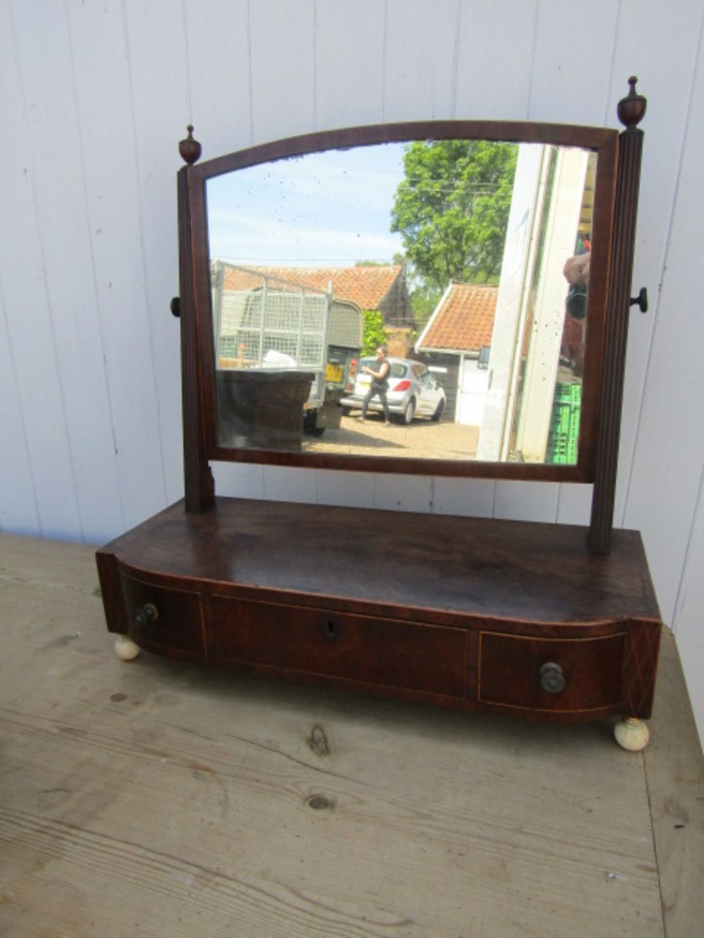 A vanity mirror with inlaid detail, porcelain feet and key