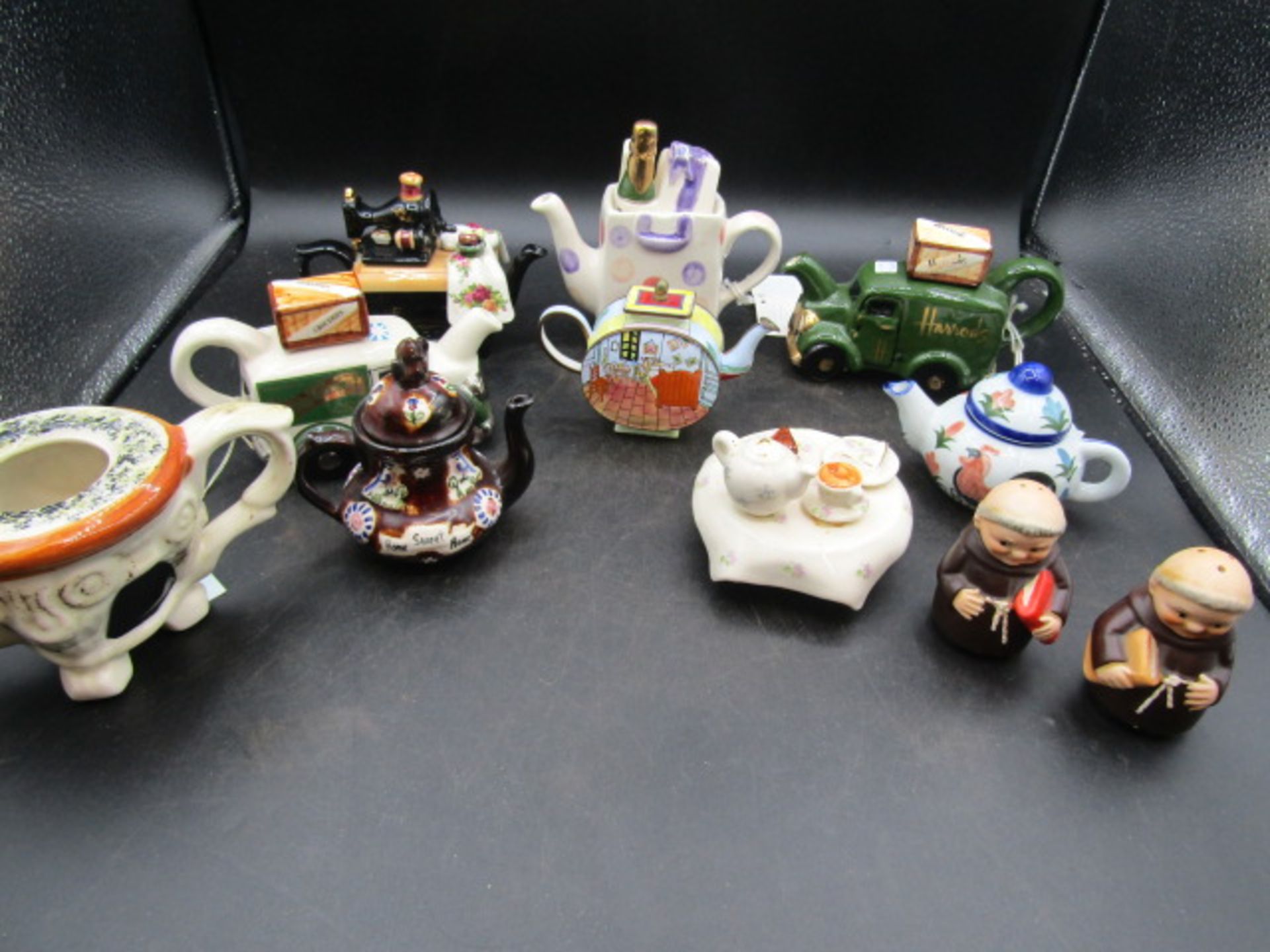 A collection of novelty teapots inc one enamelled and German priest cruet's