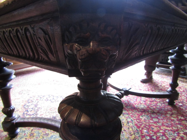 A heavily carved table with lion face details to corners 132x99cm 74cmH 2 rings missing from lion' - Image 6 of 9