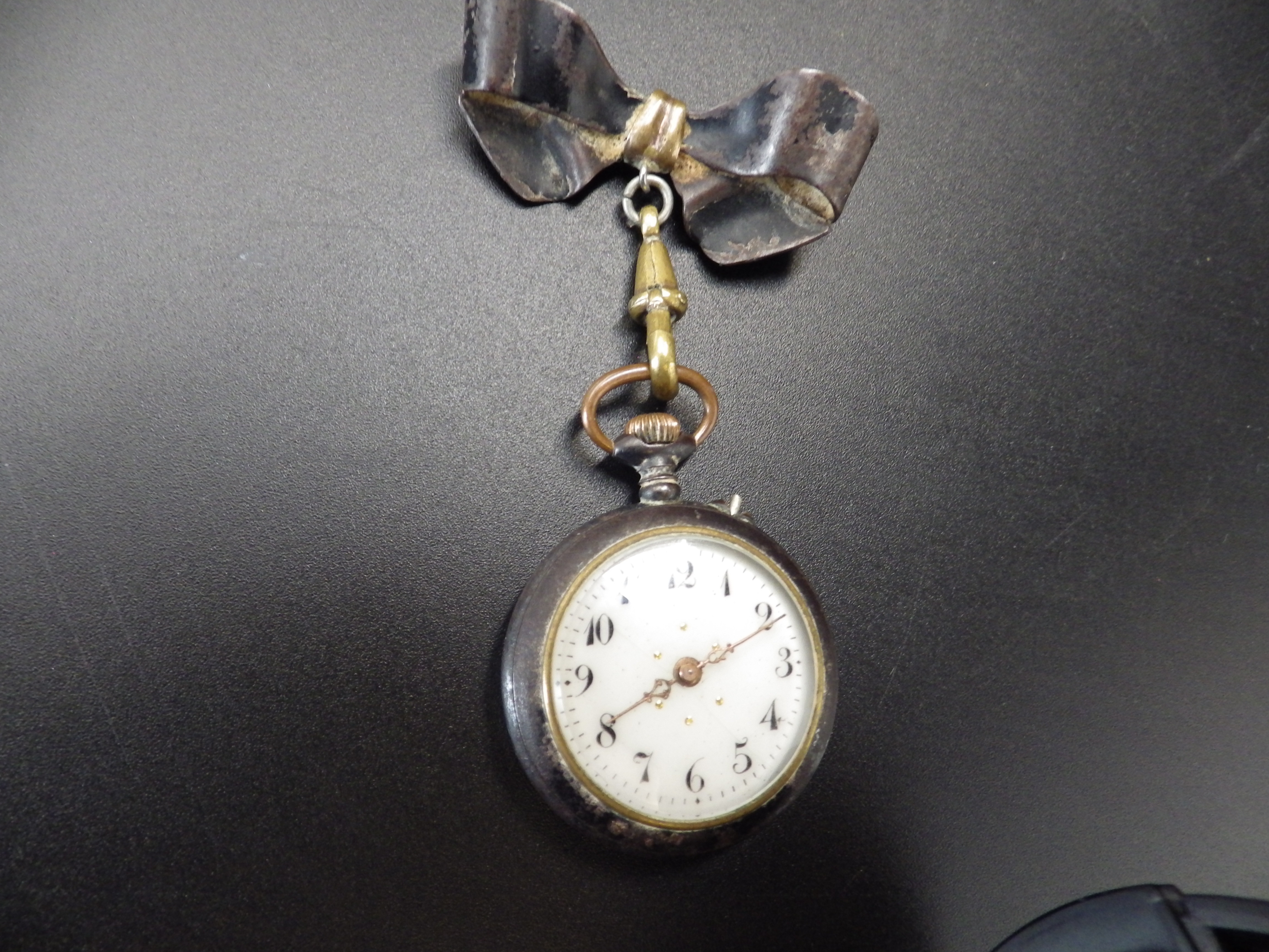 An early 20th C ladies lapel watch in a 'gun metal' case, with a bow pin fastening, and a 14ct - Image 3 of 4