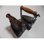 2 box irons with wooden handles one with slug the other with brass base