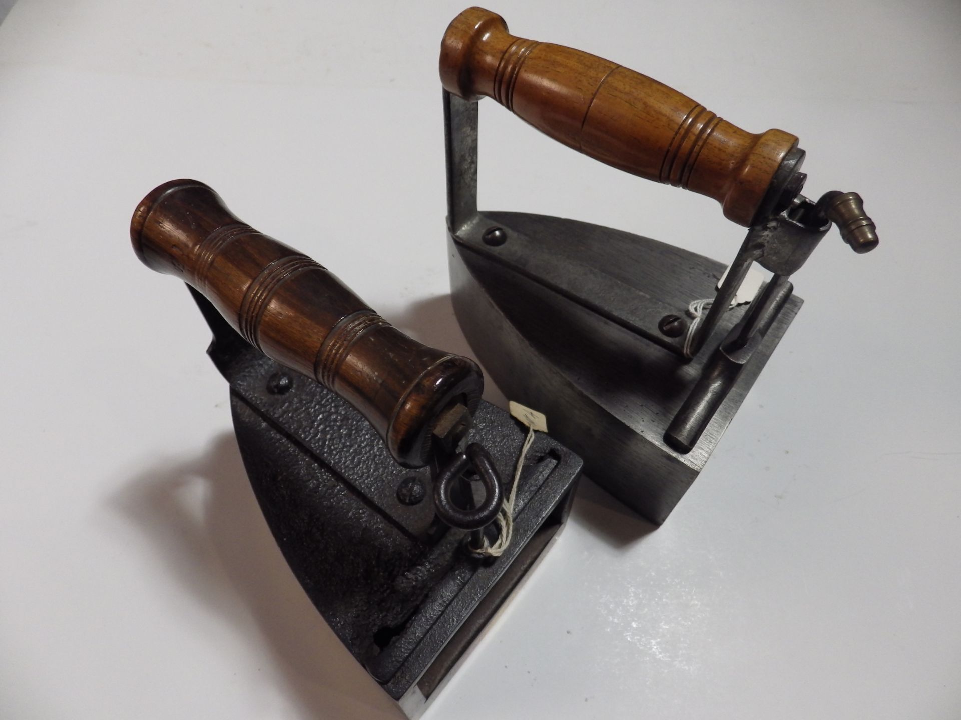 2 box irons with wooden handles one with slug the other with brass base