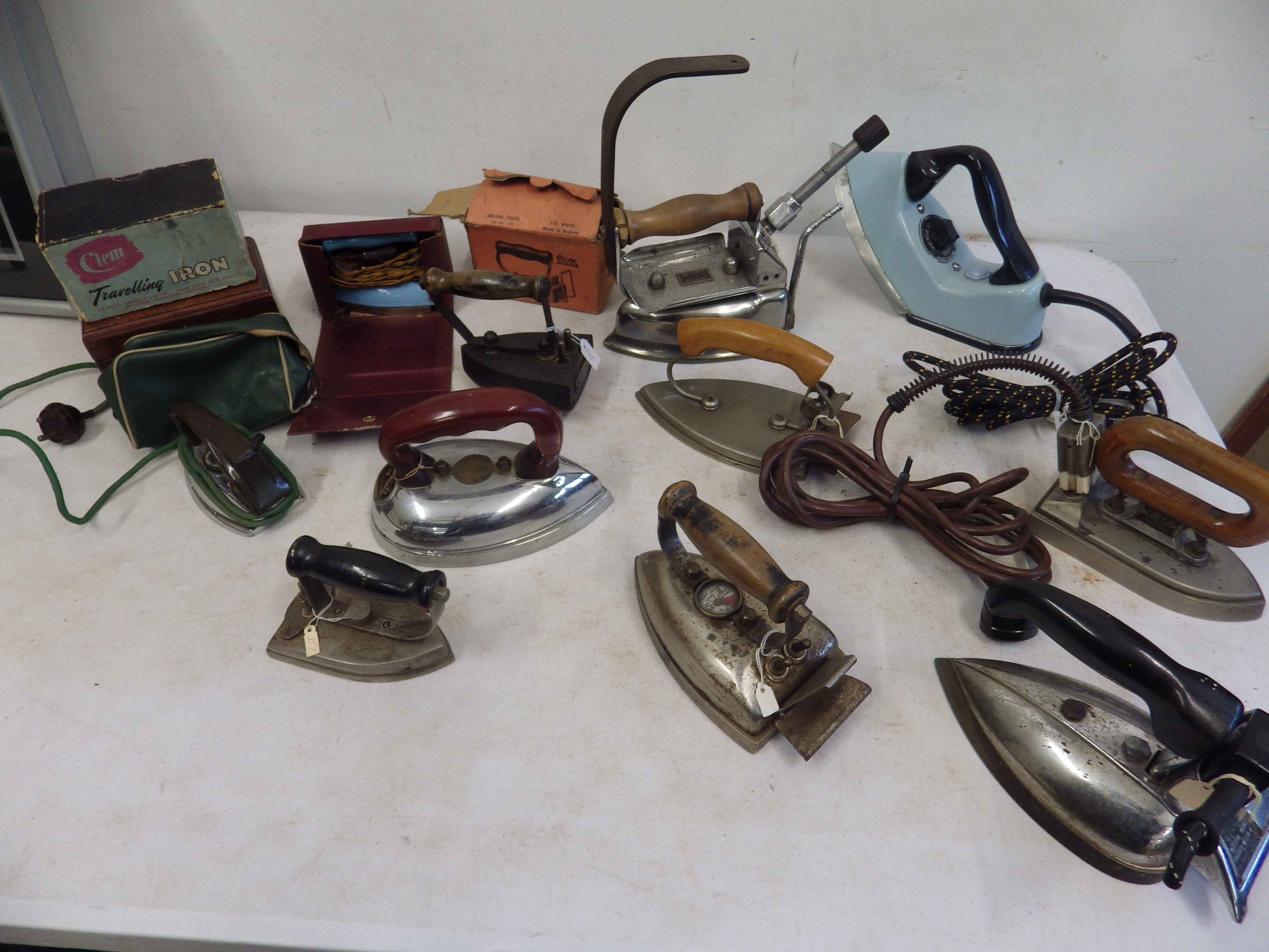 Assorted vintage electric and travel irons, some with original boxes and cases, all for display