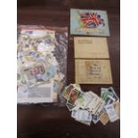 Vintage cigarette card books, loose modern cards and a bag of circulated stamps