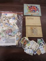 Vintage cigarette card books, loose modern cards and a bag of circulated stamps