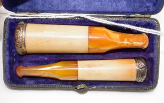 Cased set of two antique amber Cheroot holders