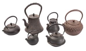 A group of six Japanese iron tetsubin [tea kettles] four cast with diaper and basket weave designs,