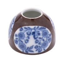 A small Meissen beehive-form inkwell painted with three underglaze blue floral panels on a brown