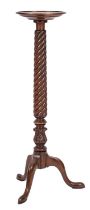 A carved mahogany circular torchere stand, in the Regency taste,