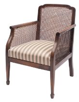 A walnut and canework library bergere chair in Regency style,