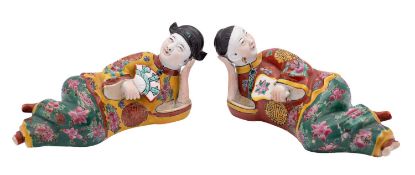 A pair of Chinese porcelain figures each in reclining posture wearing shou decorated robes and