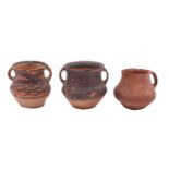 A group of three Chinese Neolithic terracotta jars two with black painted geometric decoration,