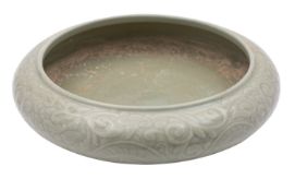 A Chinese celadon bowl of compressed form,