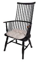 An ebonised wood stickback elbow chair, 19th century and later repainted overall; with elm seat,