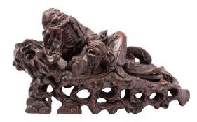A Chinese carved hardwood group of an Immortal with a Dog of Fo, late 19th/early 20th Century,